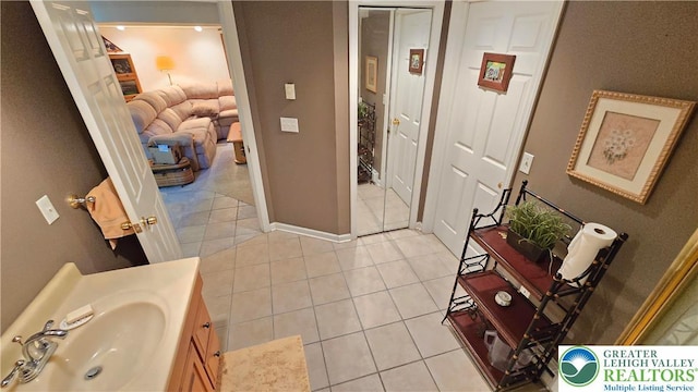 bathroom with tile patterned floors, baseboards, and vanity