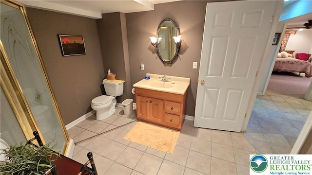 ensuite bathroom featuring tile patterned flooring, vanity, toilet, baseboards, and a shower with shower door