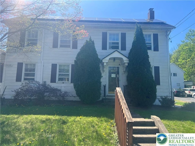 8204 Brown St, Washington Twp, PA 18079 - colonial inspired home featuring entry steps, a chimney, solar panels, and a front yard