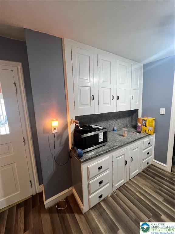 8204 Brown St, Washington Twp, PA 18079 - kitchen featuring baseboards, white cabinets, stainless steel microwave, stone counters, and dark wood-type flooring