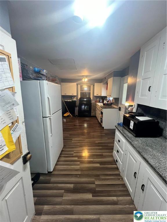 8204 Brown St, Washington Twp, PA 18079 - kitchen with freestanding refrigerator, white cabinets, range, and dark wood-style floors