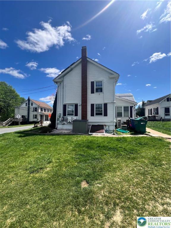 8204 Brown St, Washington Twp, PA 18079 - rear view of property featuring a yard and a chimney
