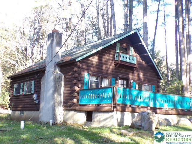 exterior space with log siding and a chimney