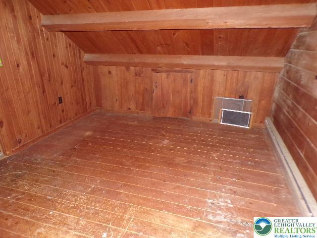 bonus room with beam ceiling, wood walls, wood ceiling, and hardwood / wood-style floors