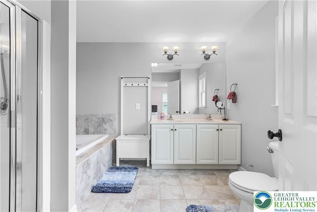 bathroom with a sink, double vanity, toilet, a shower stall, and a garden tub