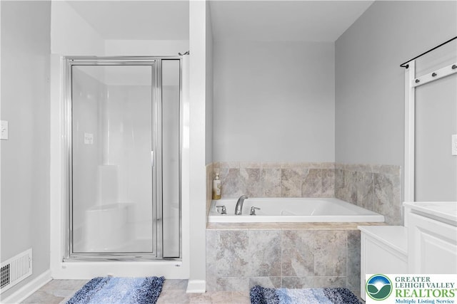 bathroom featuring visible vents, a garden tub, and a stall shower