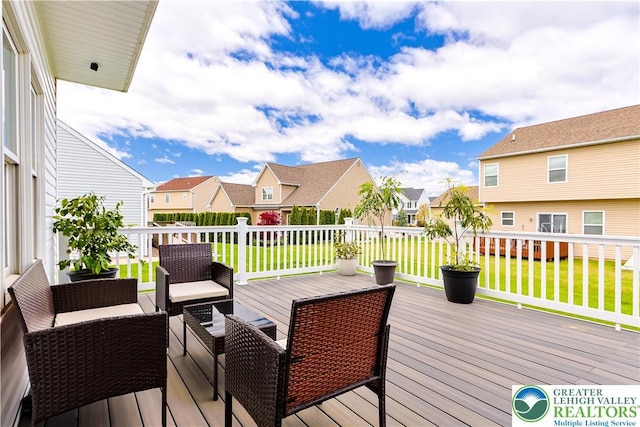 wooden terrace with a residential view, a yard, a fenced backyard, and outdoor lounge area
