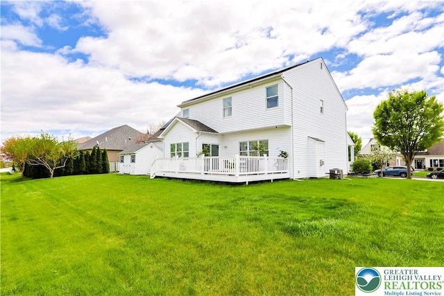 rear view of house with a lawn, cooling unit, and a wooden deck