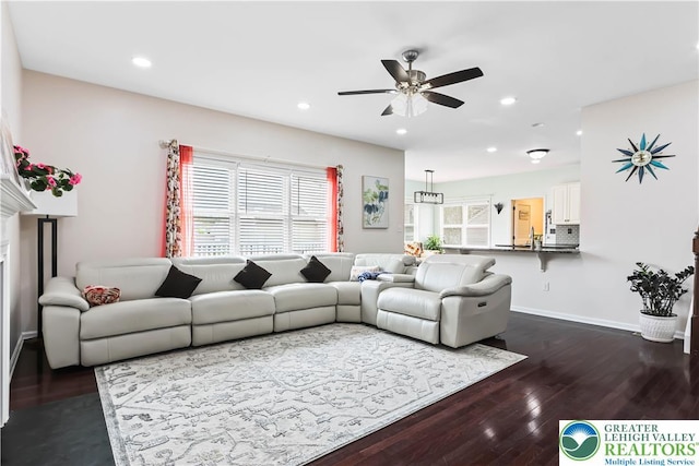 living room featuring a ceiling fan, baseboards, dark wood finished floors, and recessed lighting