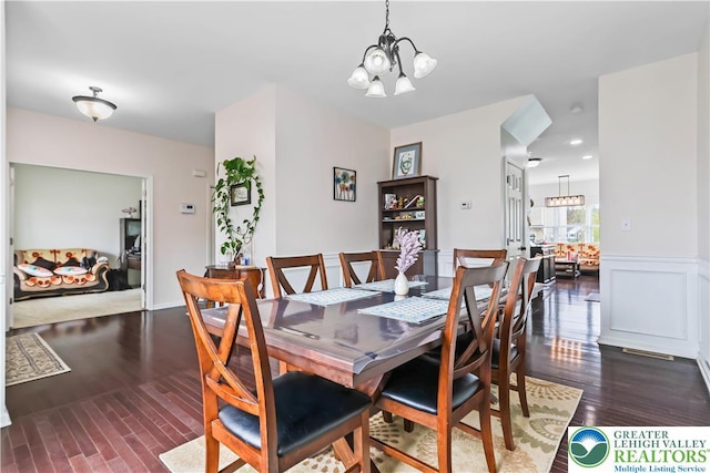 dining area featuring an inviting chandelier, recessed lighting, and dark wood-type flooring