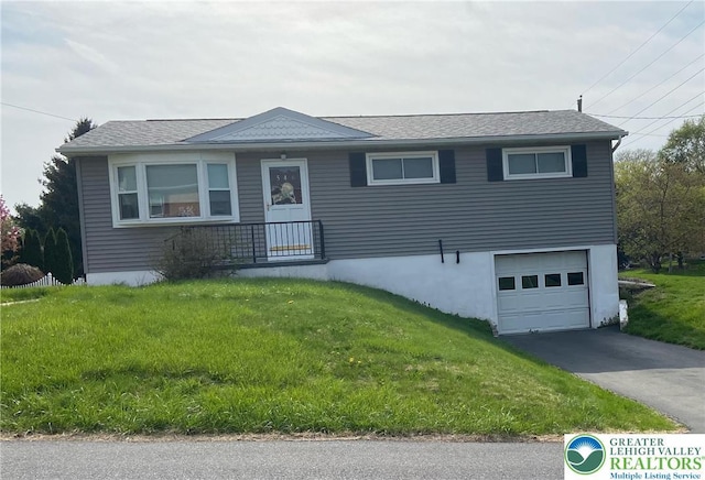 single story home featuring an attached garage, driveway, and a front lawn