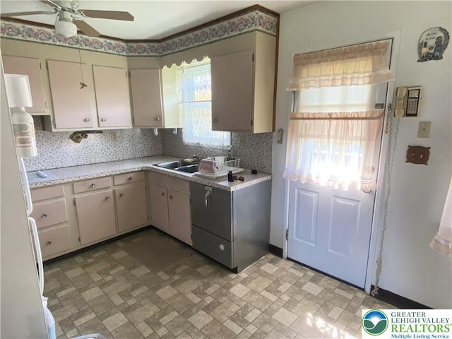 kitchen with freestanding refrigerator, decorative backsplash, brick patterned floor, ceiling fan, and light countertops