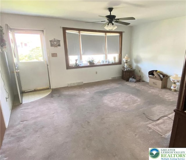 interior space with visible vents, a ceiling fan, and carpet