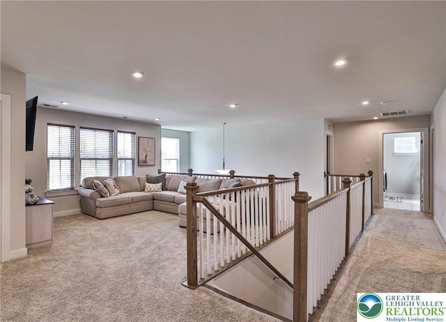 living room featuring visible vents, recessed lighting, a healthy amount of sunlight, and light carpet