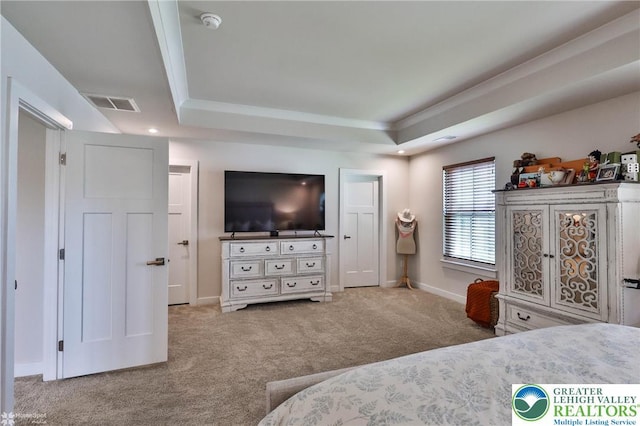 bedroom with carpet flooring, a tray ceiling, visible vents, and baseboards