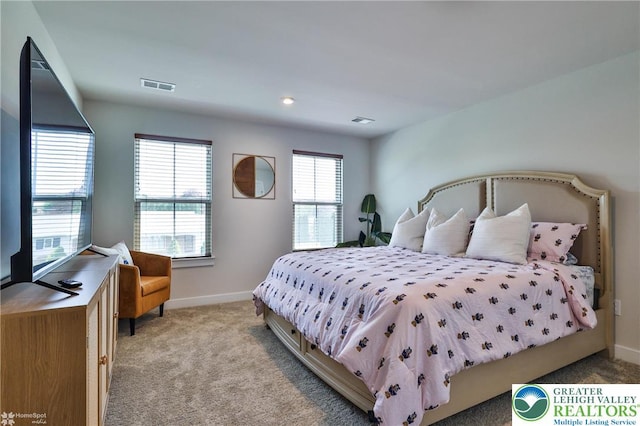 bedroom featuring baseboards, light colored carpet, and visible vents