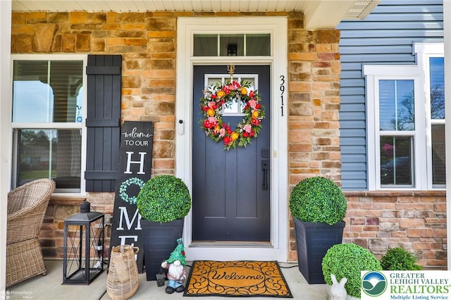 entrance to property featuring brick siding and stone siding