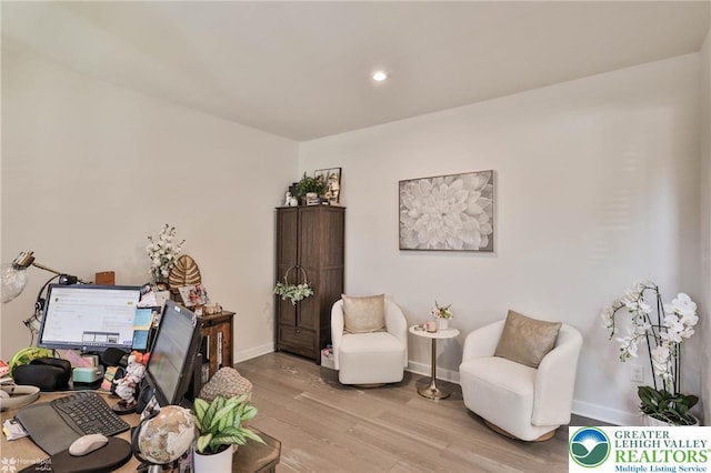 living area featuring recessed lighting, baseboards, and light wood-type flooring