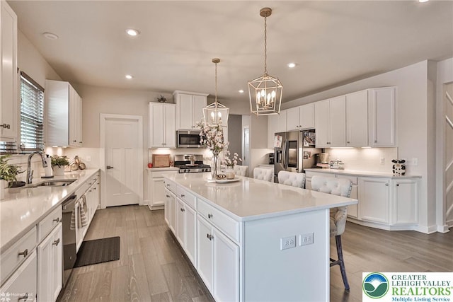 kitchen with light wood finished floors, a breakfast bar area, stainless steel appliances, tasteful backsplash, and a kitchen island