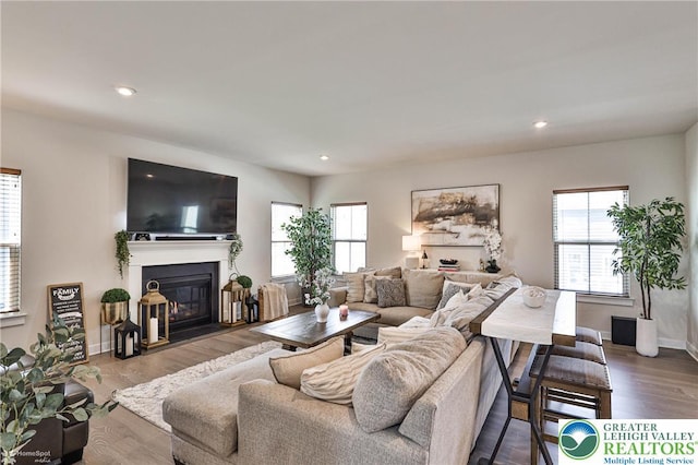 living area with a fireplace with flush hearth, plenty of natural light, and recessed lighting