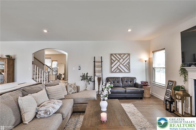 living room with stairway, arched walkways, recessed lighting, and wood finished floors