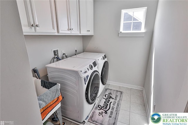 washroom with baseboards, cabinet space, light tile patterned floors, and washing machine and dryer