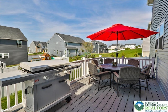 deck with grilling area, a residential view, and outdoor dining space