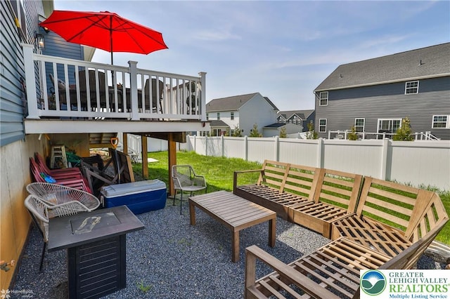 view of patio with a deck, a residential view, fence, and a fire pit