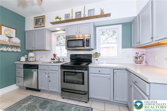 kitchen with a sink, light countertops, backsplash, and stainless steel appliances