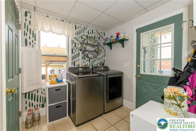 washroom featuring laundry area, light tile patterned flooring, washer and dryer, baseboards, and wallpapered walls
