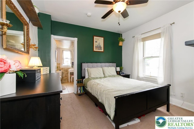 bedroom featuring carpet flooring, ceiling fan, baseboards, and ensuite bathroom