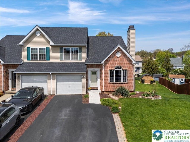 view of front of property with aphalt driveway, a chimney, fence, a front lawn, and a shingled roof