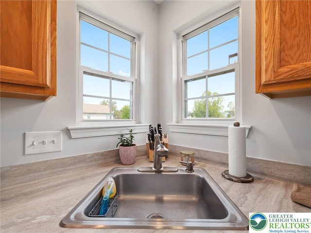 details featuring brown cabinetry, a sink, and light countertops