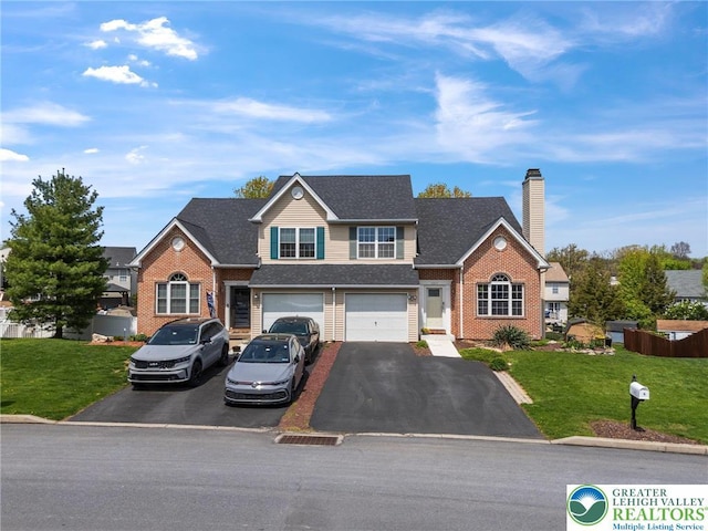 view of front of property with driveway, a chimney, a front yard, brick siding, and an attached garage