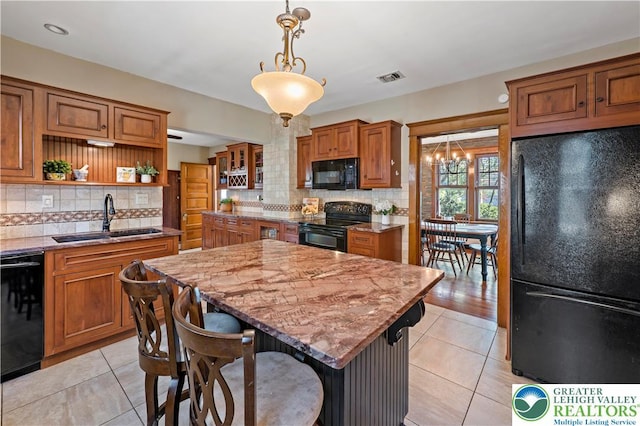 kitchen featuring visible vents, open shelves, light tile patterned flooring, a sink, and black appliances