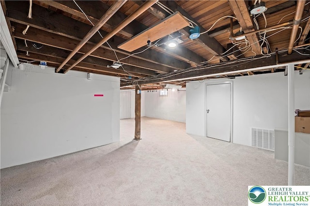 finished below grade area with visible vents and light carpet