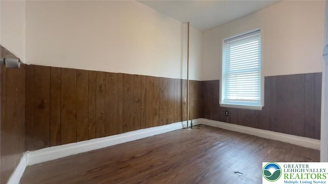 1541 W Tilghman St, Allentown City, PA 18102 - empty room featuring baseboards, wood walls, wood finished floors, and a wainscoted wall