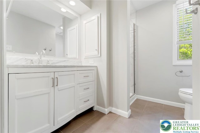 bathroom with vanity, baseboards, a stall shower, and toilet