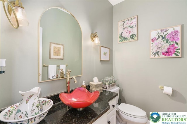 half bathroom featuring toilet and vanity
