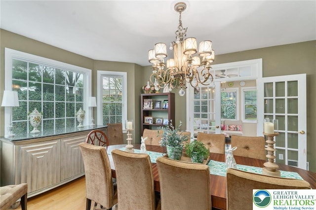 dining room featuring an inviting chandelier and light wood-style flooring