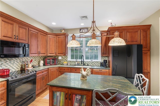 kitchen featuring visible vents, a sink, backsplash, and black appliances