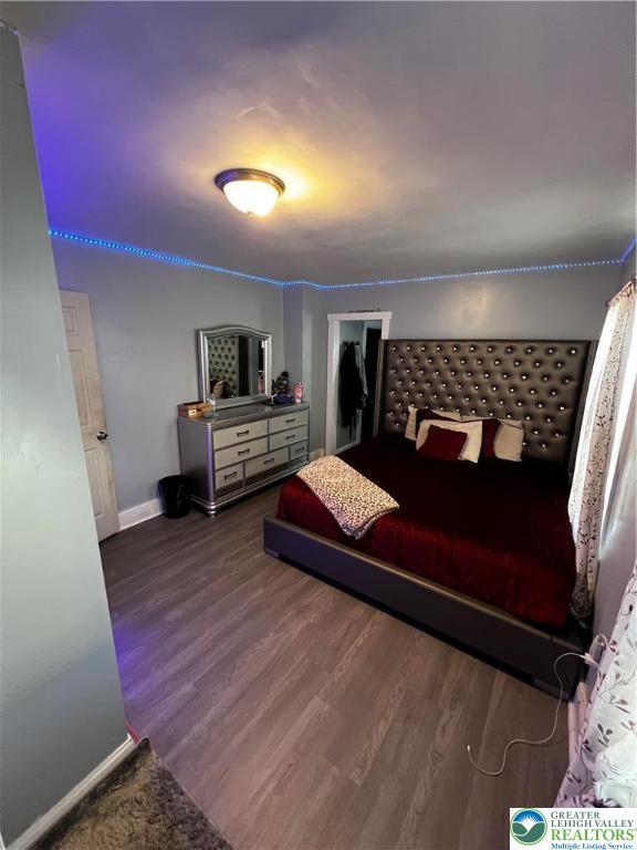 bedroom featuring baseboards and wood finished floors