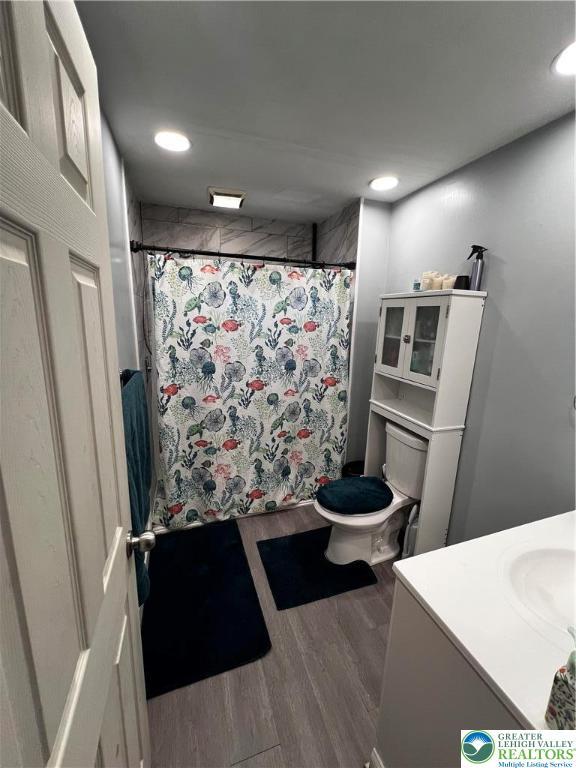 bathroom featuring recessed lighting, curtained shower, wood finished floors, and vanity