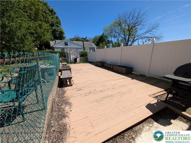 wooden deck with fence, an outbuilding, and a shed