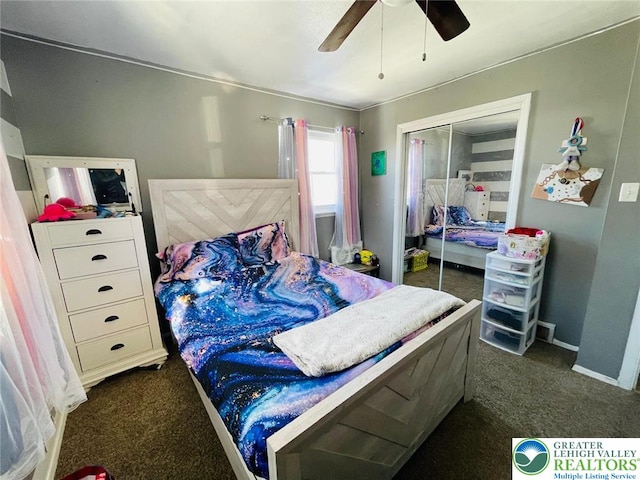 bedroom with dark colored carpet, baseboards, ceiling fan, and a closet
