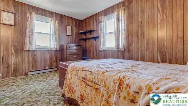 bedroom with carpet flooring, a baseboard heating unit, and wood walls