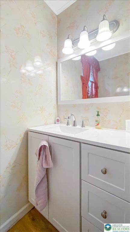 bathroom with wallpapered walls and vanity