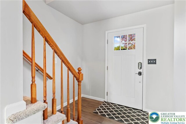 entrance foyer with stairs, baseboards, and wood finished floors
