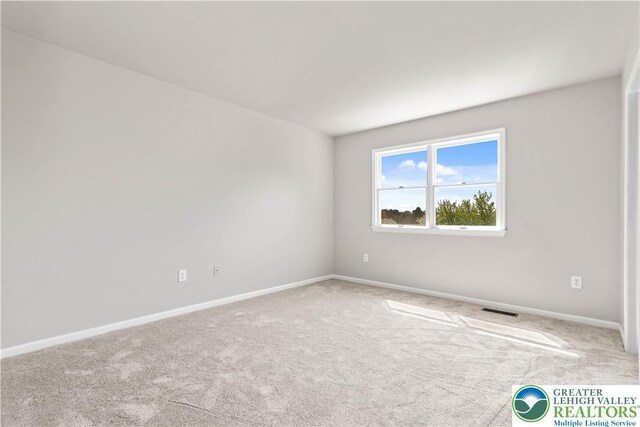 carpeted empty room featuring visible vents and baseboards