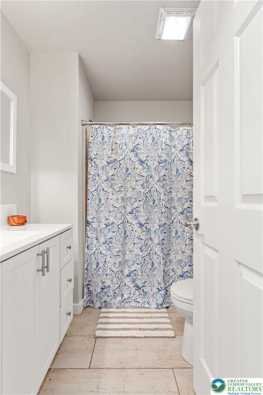 bathroom with vanity, wood finished floors, toilet, and a shower with curtain